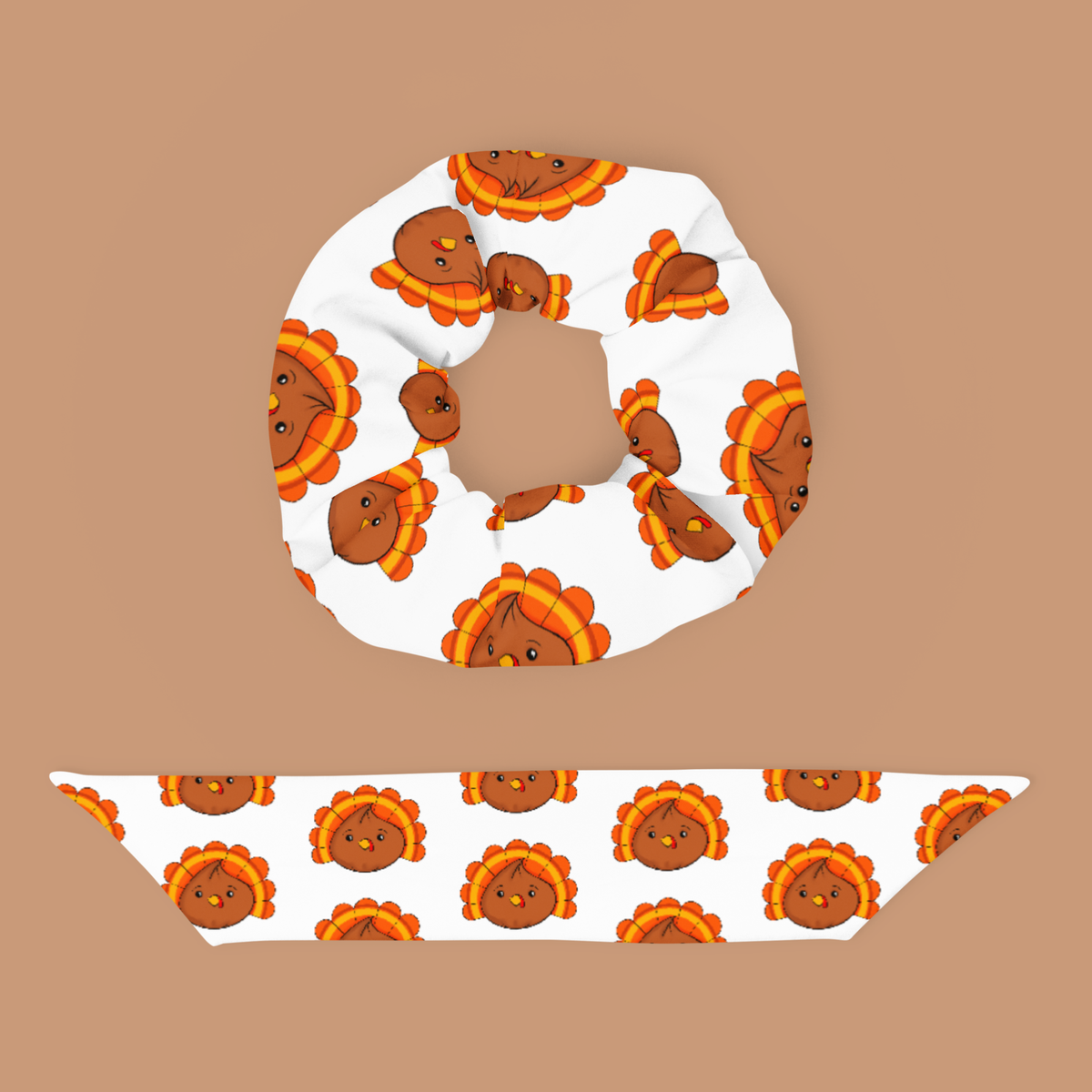 White turkey dumpling scrunchie displayed above its detached matching bow, showing the repeating brown, orange, and yellow pattern.