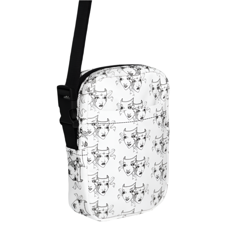 A white crossbody bag featuring a black-and-white theatre mask design, symbolizing comedy and tragedy. The bag includes an adjustable black shoulder strap, sturdy fabric construction, and inside and outside pockets for convenient storage. A two-way zipper ensures easy access to the bag's contents. Icon labels next to the bag highlight its adjustable strap, inside and outside pocket features, sturdy fabric, and two-way zipper functionality.