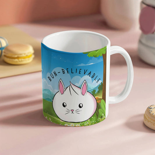 Cute bunny mug with the phrase 'Bun-Believable' in a bright outdoor landscape with trees and flowers, kawaii rabbit coffee cup with pun design.