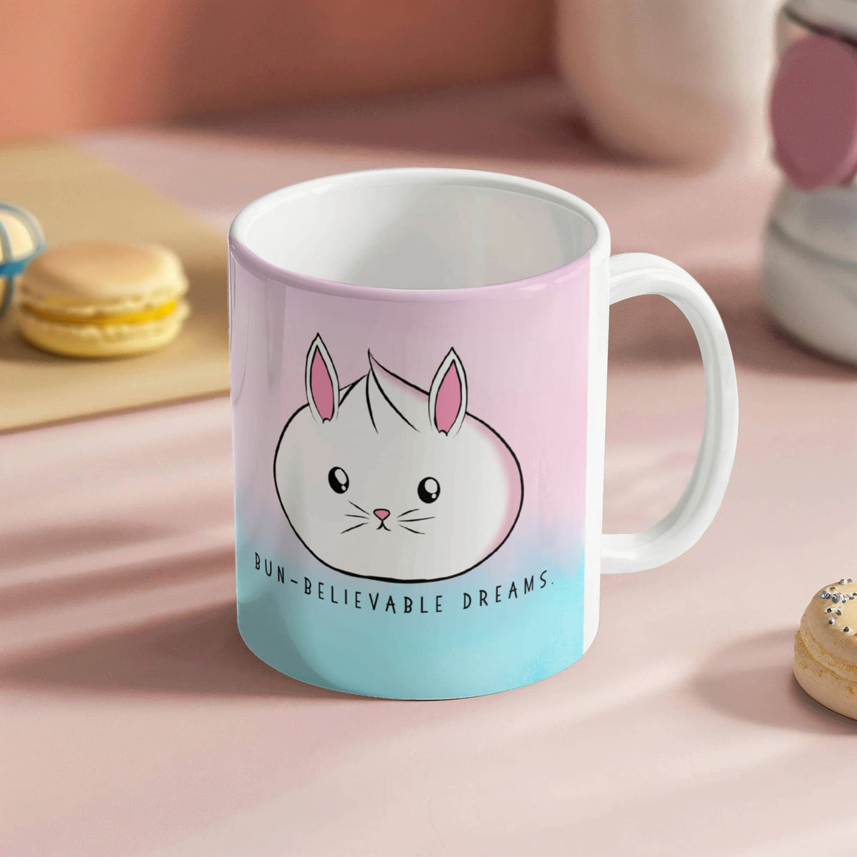 Cute bunny mug with pastel pink and blue background and the phrase 'Bun-Believable Dreams', kawaii rabbit coffee cup with inspirational quote.