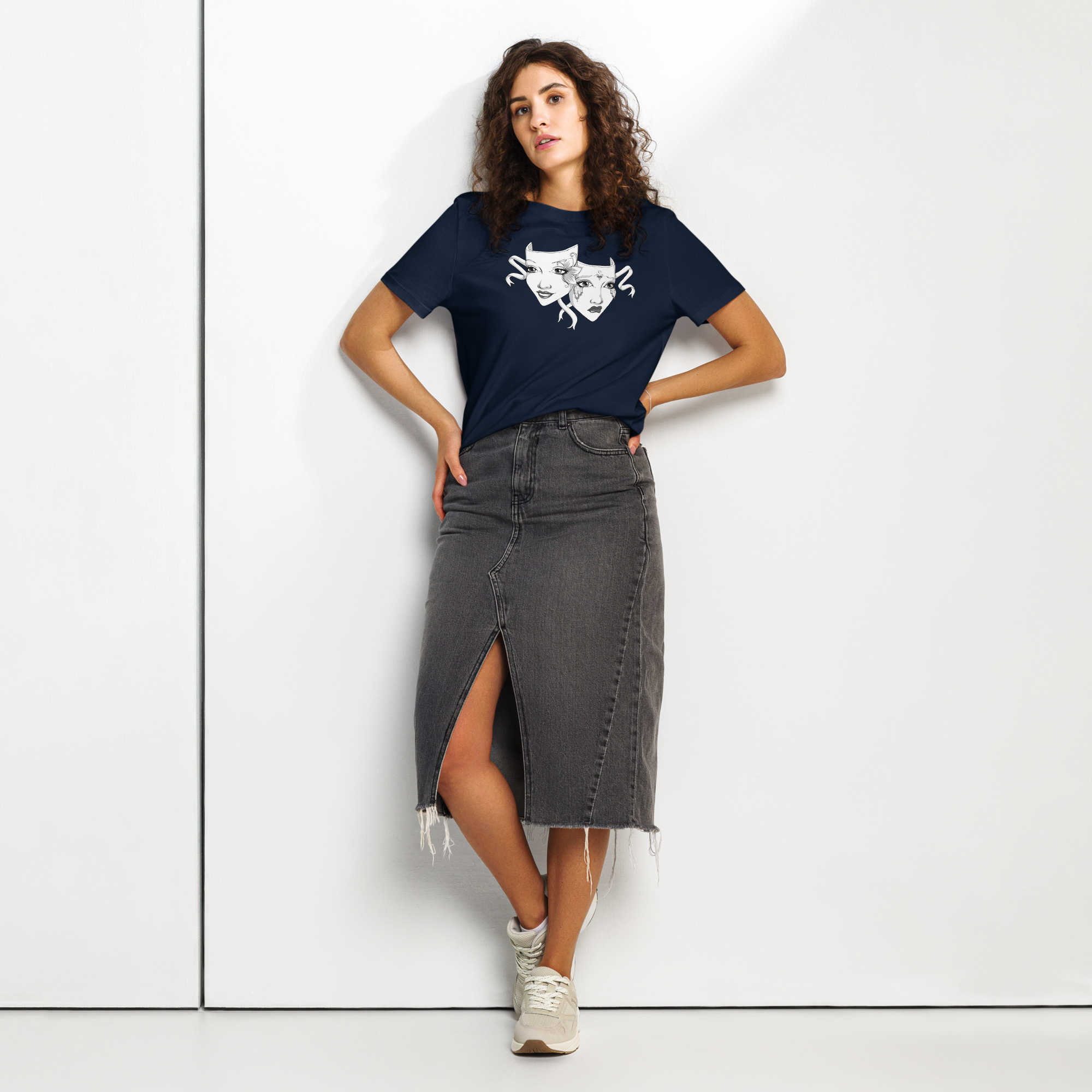 Woman wearing a navy blue organic cotton t-shirt with white gothic theatre masks design, paired with a modern denim skirt.